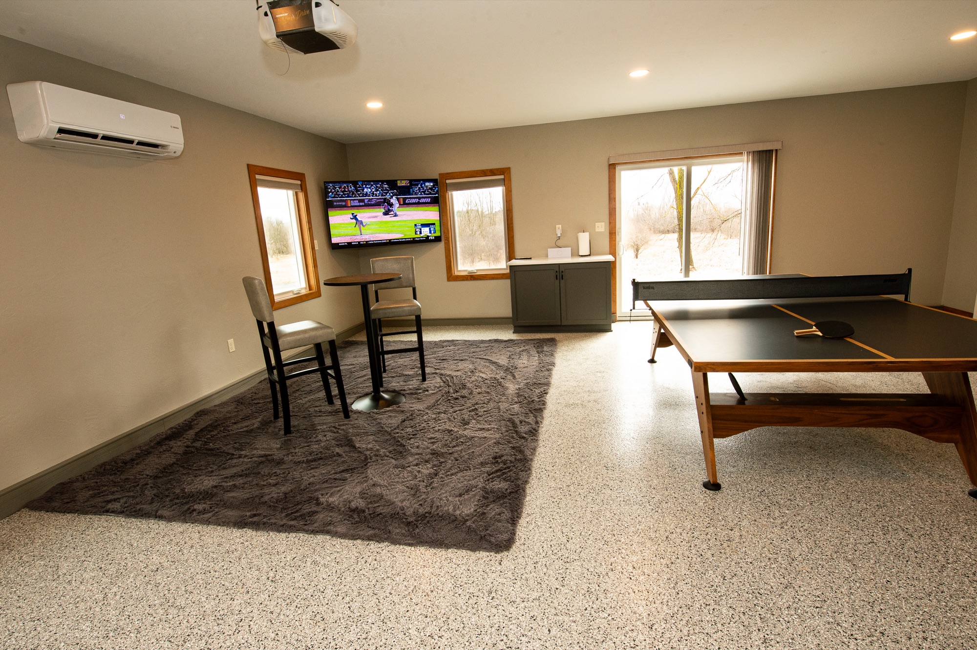 Game room with ping-pong table and mounted TV