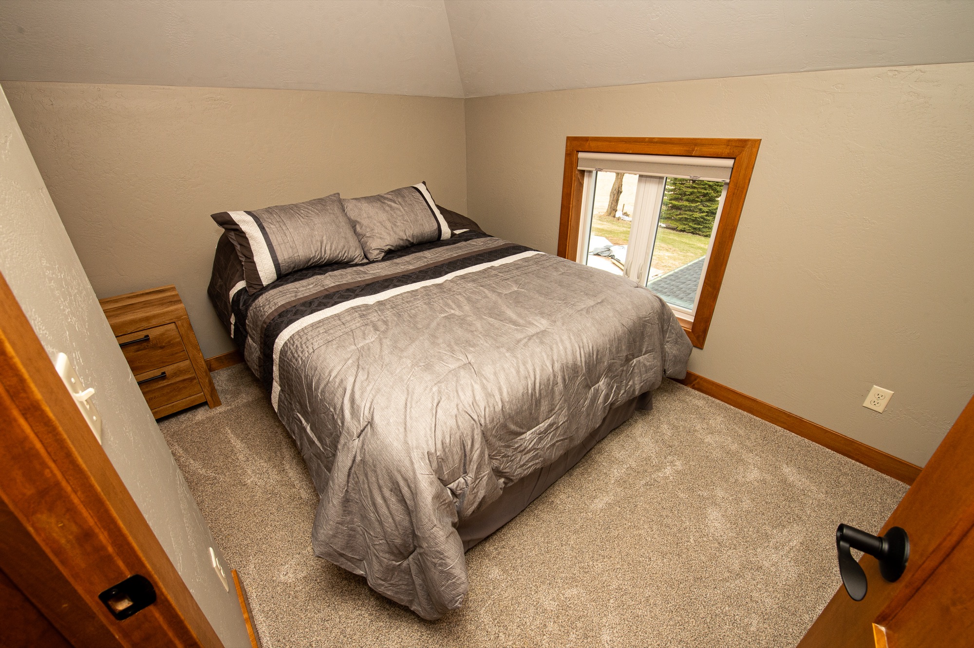 Upstairs bedroom with queen bed and country view