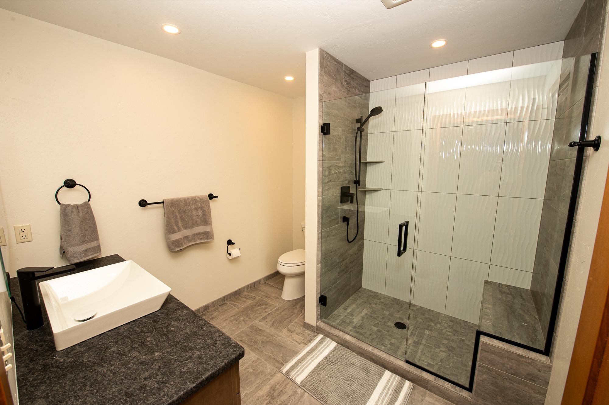 Spa-inspired bathroom with walk-in glass shower and vessel sink